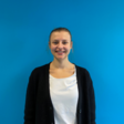 Dozentin Julia Schneider vor blauem Hintergrund