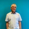Dozent Peter Minko vor blauem Hintergrund