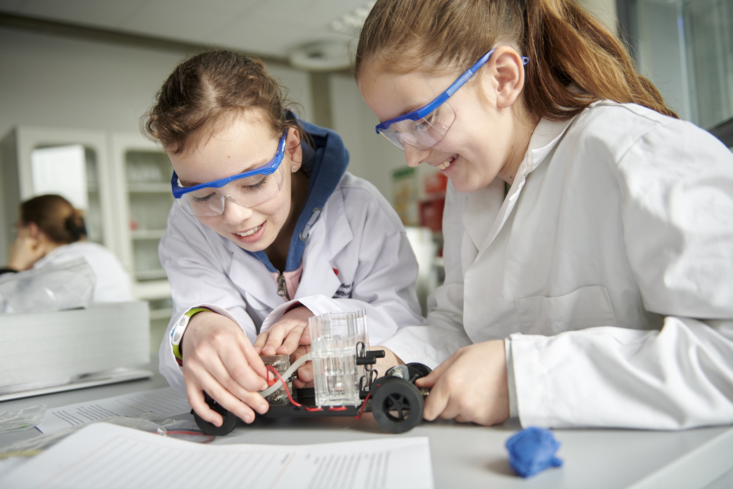 Zwei Junior Uni-Student*innen experimentieren mit Brennstoffzellen.